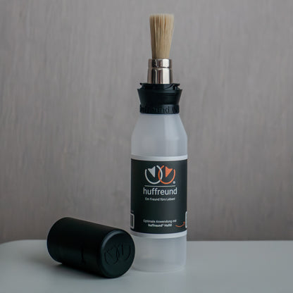 huffreund-Pinselflasche Compact für Huföl auf Pferdehufen steht vor schlichtem Hintergrund zu Präsentationszwecken.