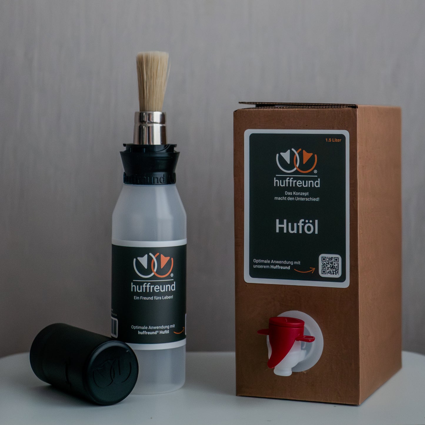 huffreund-Pinselflasche Compact mit Huföl für Pferdehufe in einer Bag-In-Box 1,5L stehen vor schlichtem Hintergrund zu Präsentationszwecken.