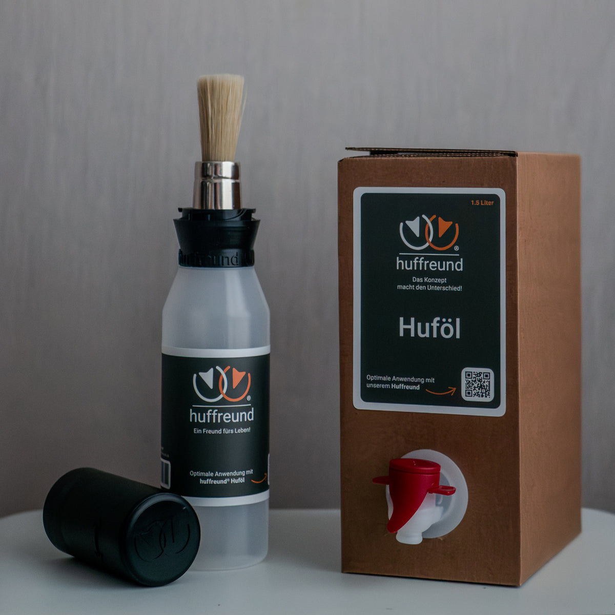 huffreund-Pinselflasche Compact mit Huföl für Pferdehufe in einer Bag-In-Box 1,5L stehen vor schlichtem Hintergrund zu Präsentationszwecken.
