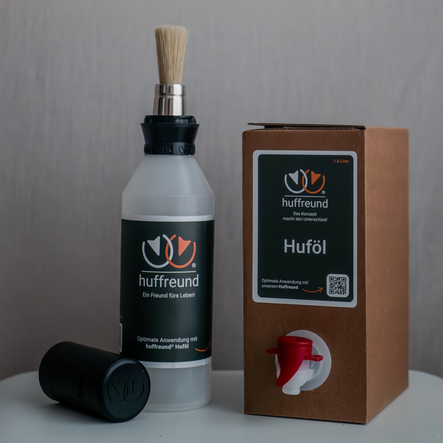 huffreund-Pinselflasche Pro mit Huföl für Pferdehufe in einer Bag-In-Box 1,5L stehen vor schlichtem Hintergrund zu Präsentationszwecken.